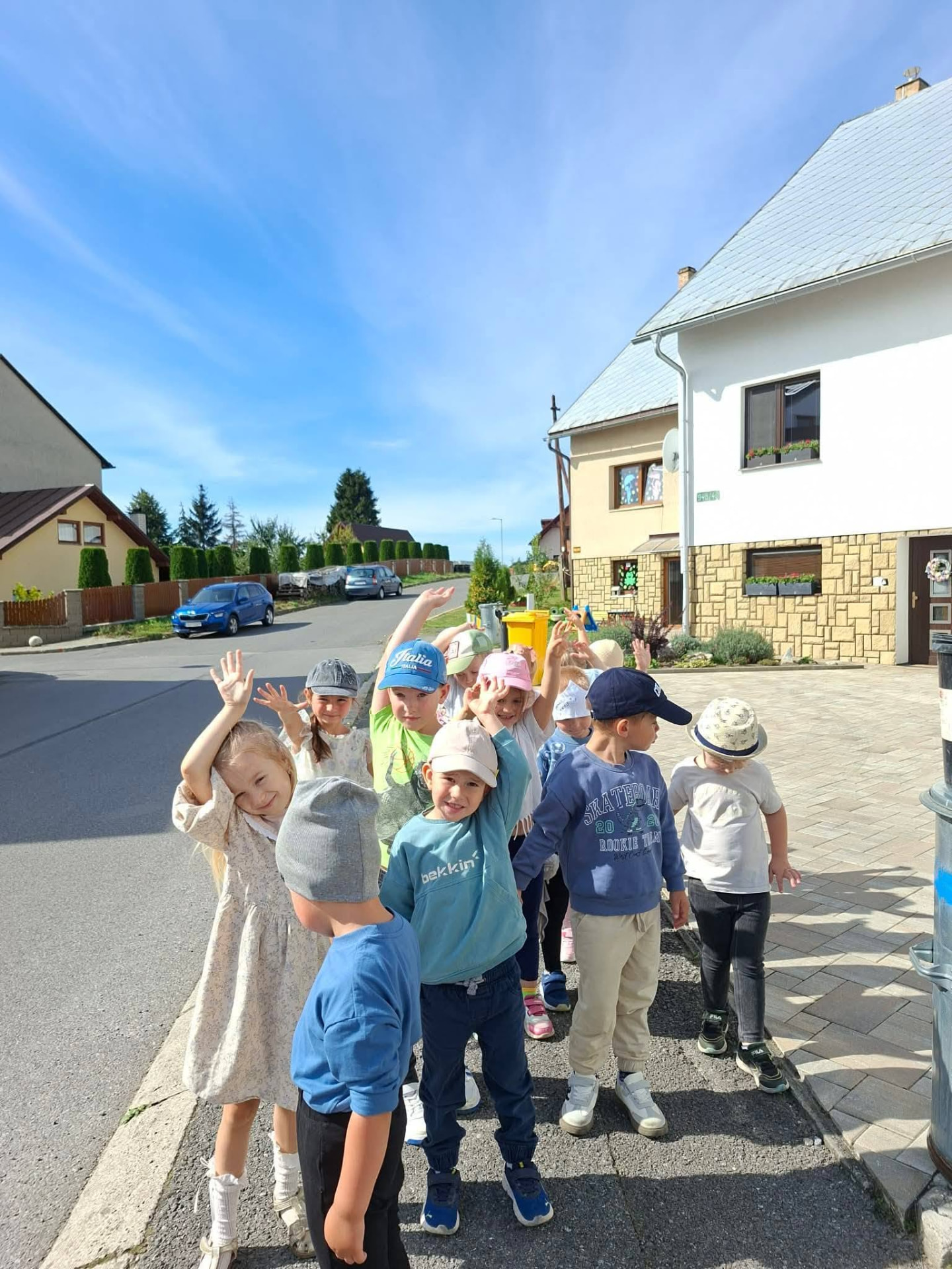 Children waving on a walk outside the centre